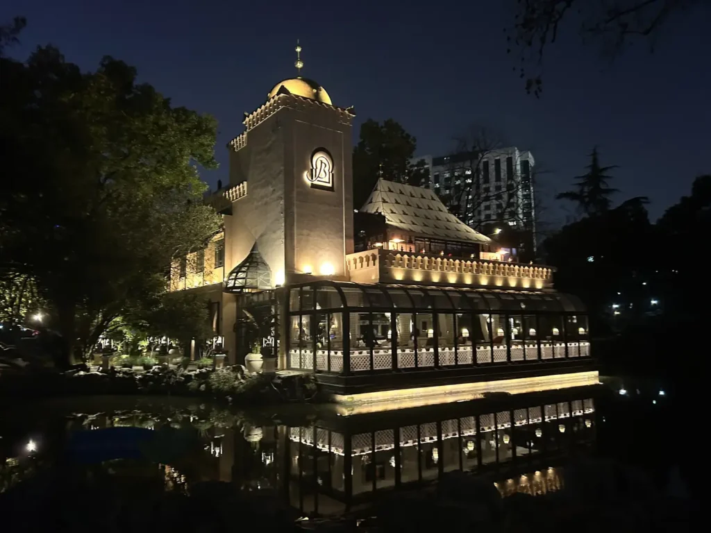 Barbarossa bar in the middle of People's Park Shanghai overlooking a small pond at night.