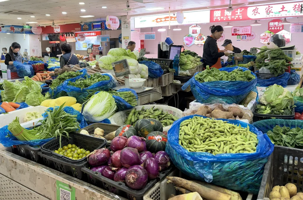 Wet markets in Shanghai — vendors selling fresh vegetables and produce at a local market stall