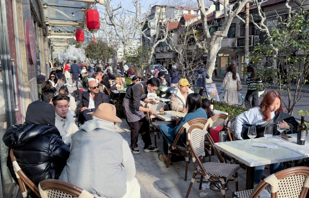 People enjoying wine at a wine bar on an outdoor patio in the former French concession in Shanghai