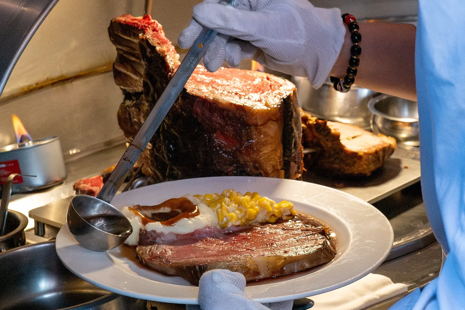 A plate of prime rib being prepared by a chef at Lawry's The Prime Rib in Shanghai