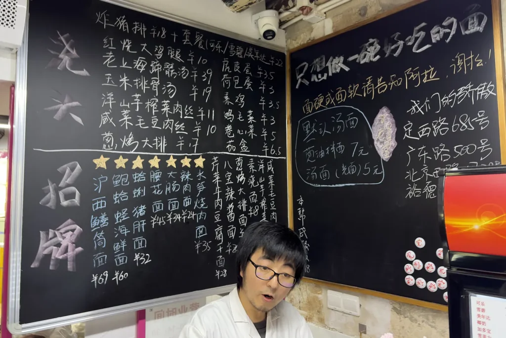 Cashier and menu on a blackboard at Huxi Old Alley Noodles in Shanghai