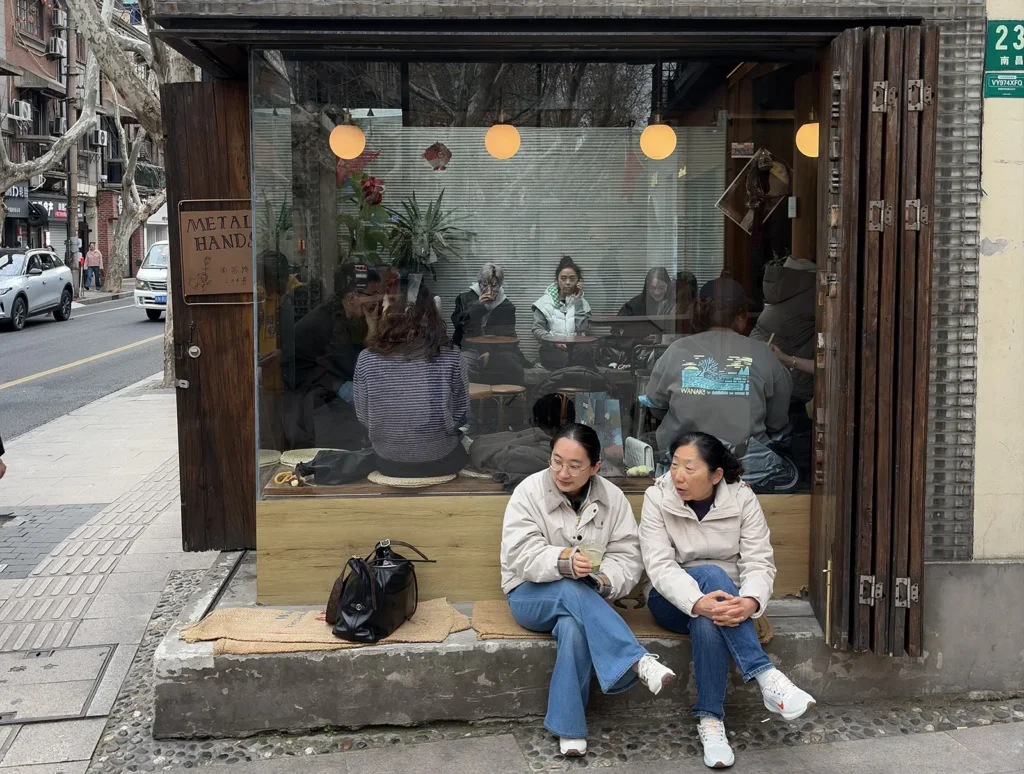 Customers sitting outside Metal Hands coffee shop on Nanchang Road in the former French Concession, Shanghai
