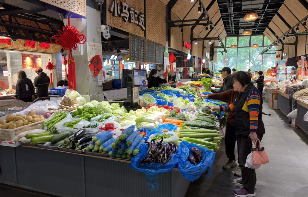 Shoppers inspecting the vegetables at My Home wet market in Changning district, Shanghai