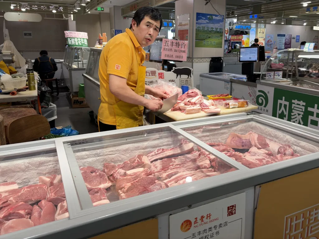 Pork vendor chopping meat at Fu Zhong wet market in Shanghai