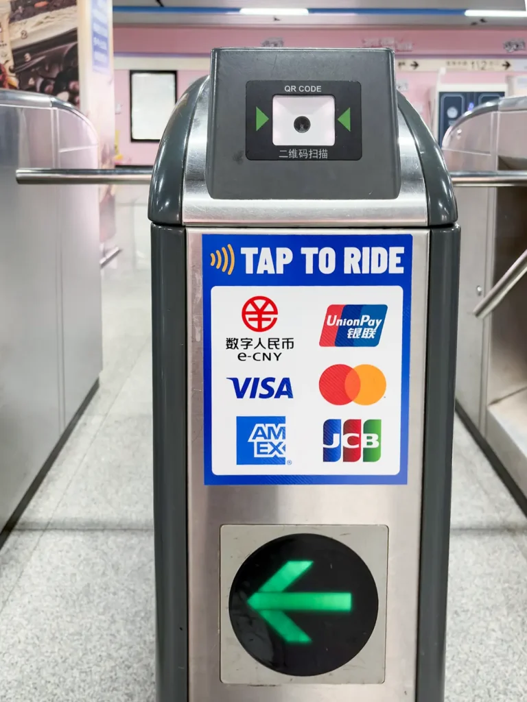 Shanghai metro turnstile with contactless payment options including Visa, Mastercard, UnionPay, AMEX, JCB, and digital RMB.